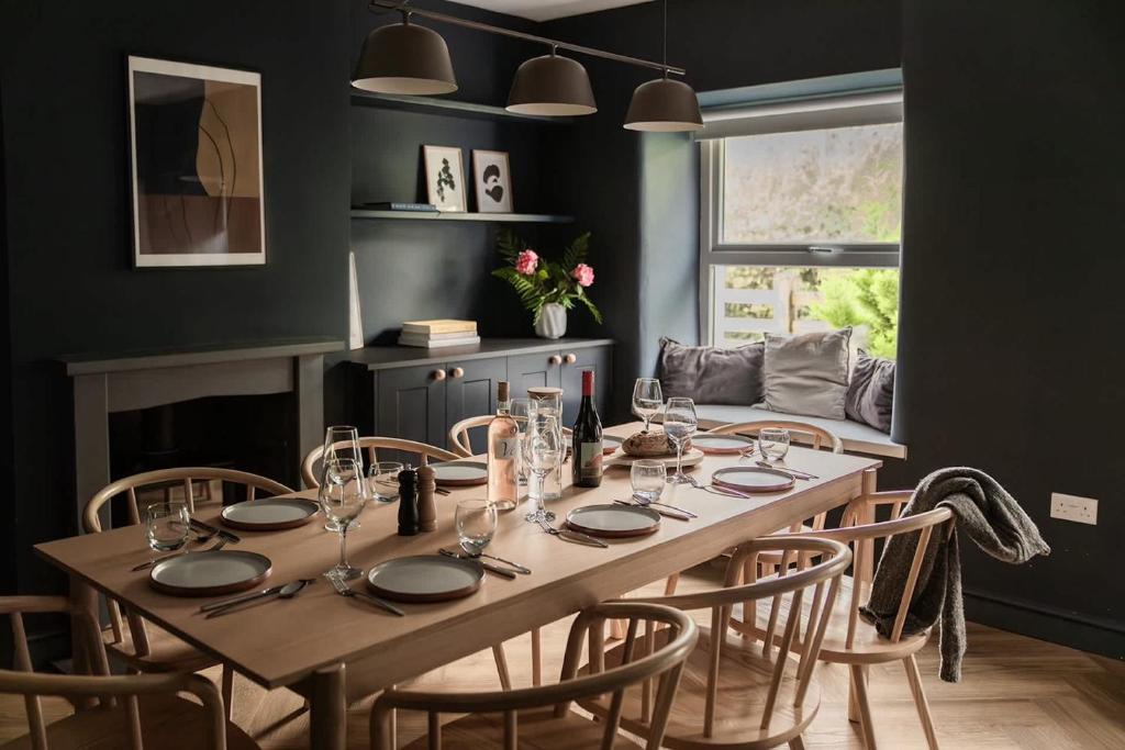 ein Esszimmer mit einem Holztisch und Stühlen in der Unterkunft A Beautiful 3 Bedroom 17th Century Stone cottage in Llanddyfnan