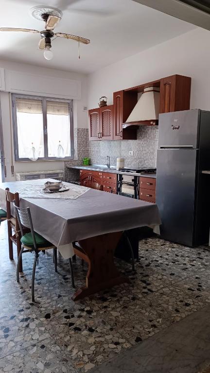 a kitchen with a table and a refrigerator at Casa di Silla in Torre del Lago Puccini