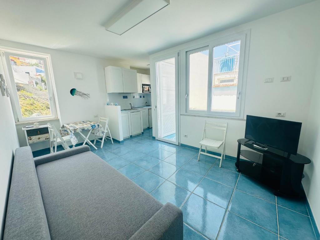 a living room with a couch and a table and a kitchen at Acquario - Immobilevante in Ponza