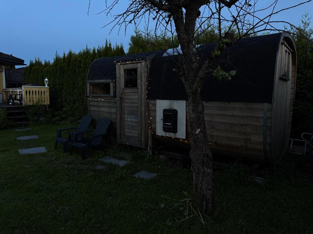 an old rv sitting in the grass next to a tree at Just Like Home Bed & Spa Porsgrunn in Porsgrunn