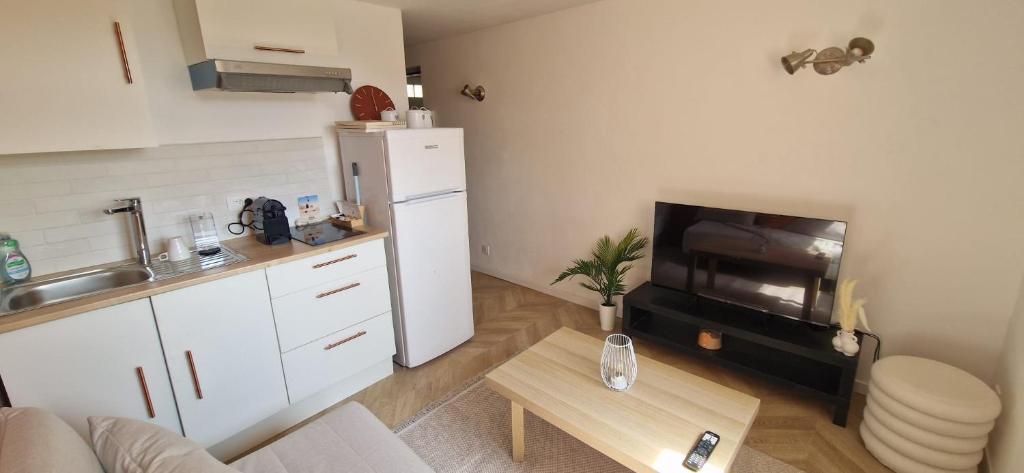 une cuisine avec un réfrigérateur blanc et une table dans l'établissement Marseille Frioul, à Marseille