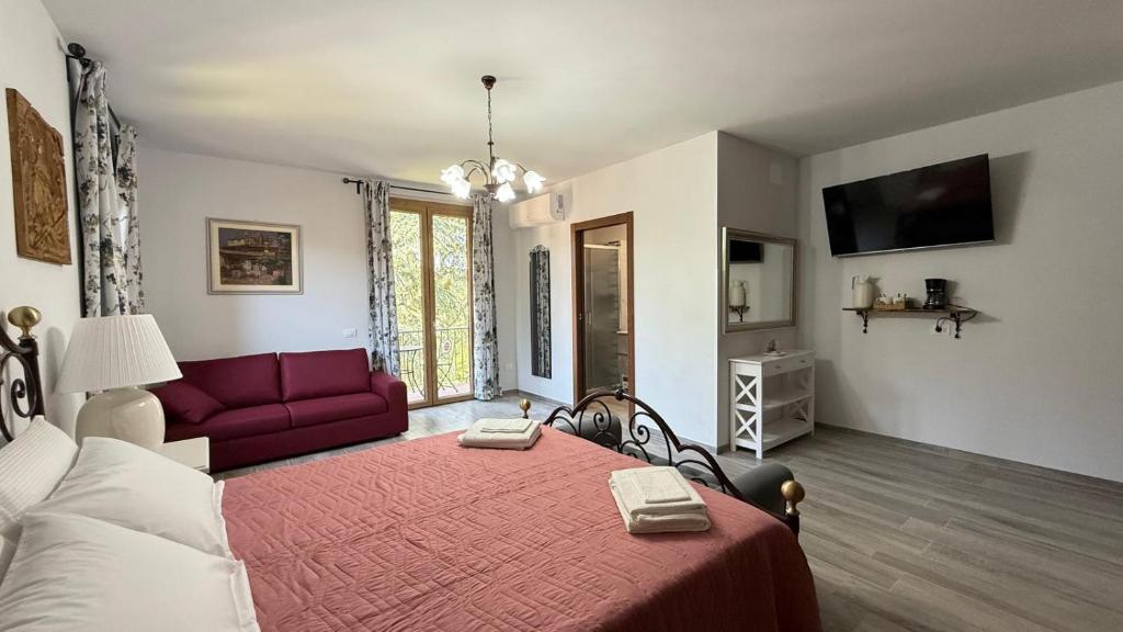 a bedroom with a red bed and a red couch at Villa Casavecchia Caselli in Dicomano
