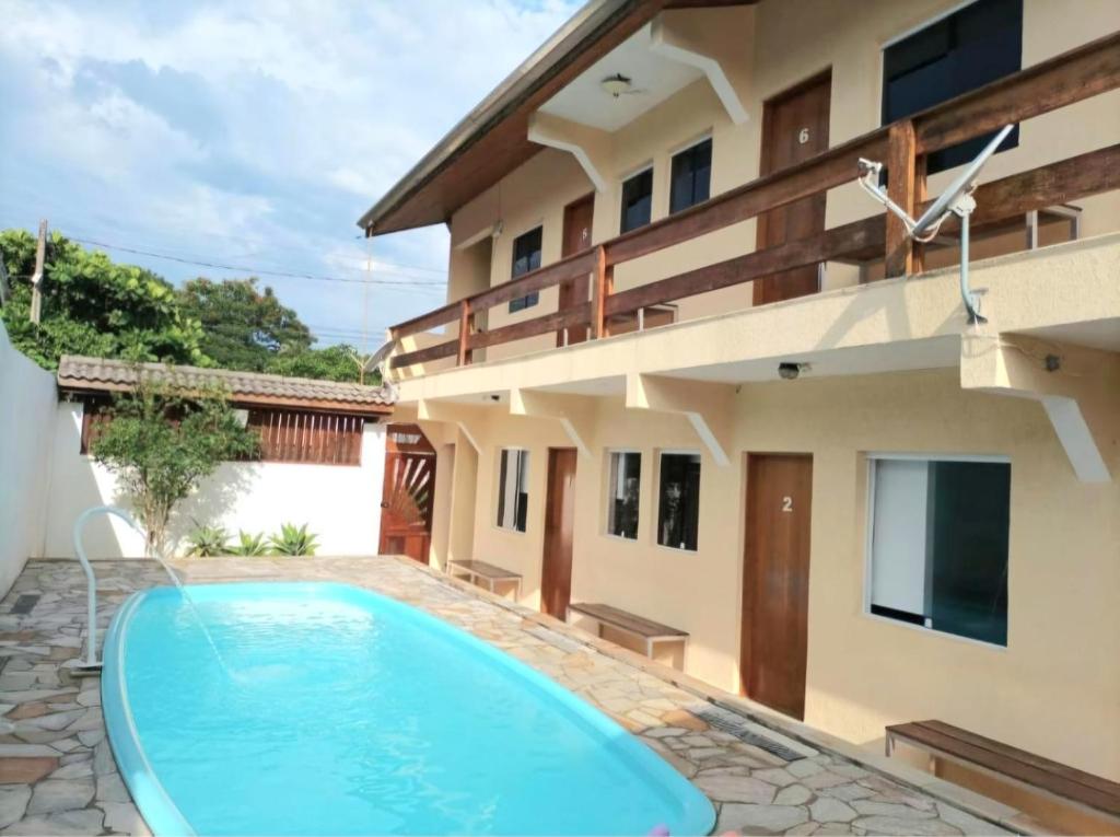 ein Swimmingpool vor einem Haus in der Unterkunft Hospedagem Econômica Flor de Maria 2 in Caraguatatuba