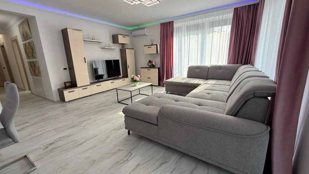 ein Wohnzimmer mit Sofa und Fernseher in der Unterkunft Mara Stefania Apart Hotel Deluxe in Oradea
