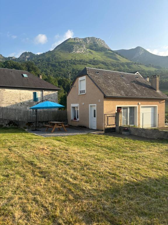 a house with a picnic table and a mountain in the background at Gîte Bellevue in Ossen