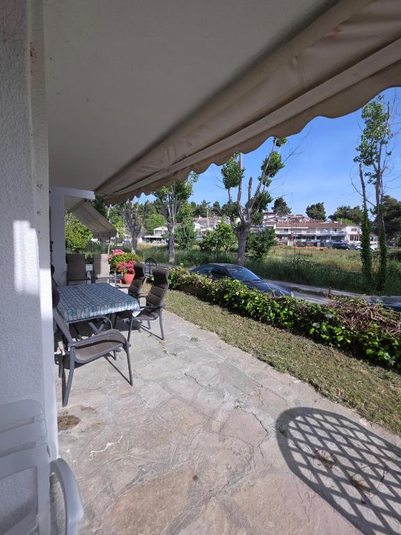 a patio with a table and chairs on it at Pati's summer house in Siviri