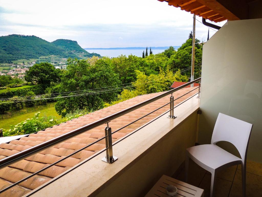 a balcony with a chair and a view of the ocean at B&B IL RICCIO in Costermano