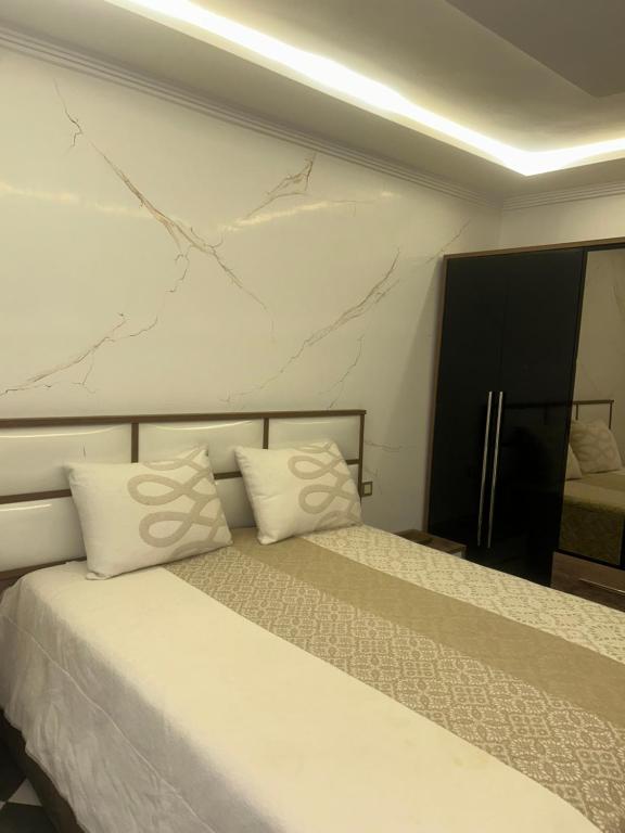 a bedroom with a bed with two white pillows at Appartement Belyouneche in Belyounech 