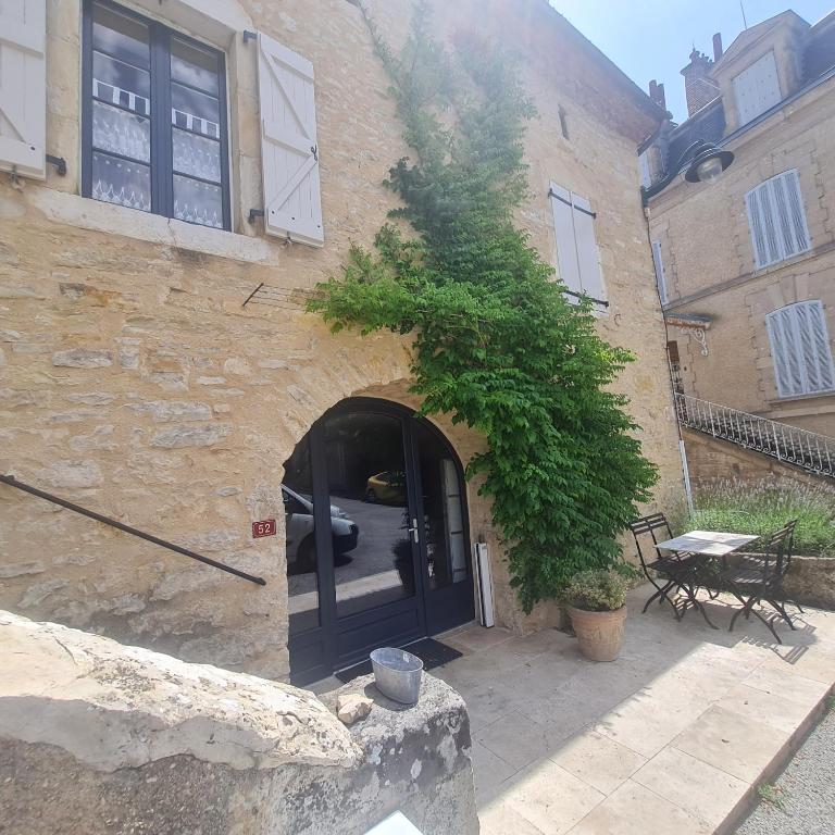 - un bâtiment en pierre avec une porte et un arbre dans l'établissement Mas de Mandirac, à Varen