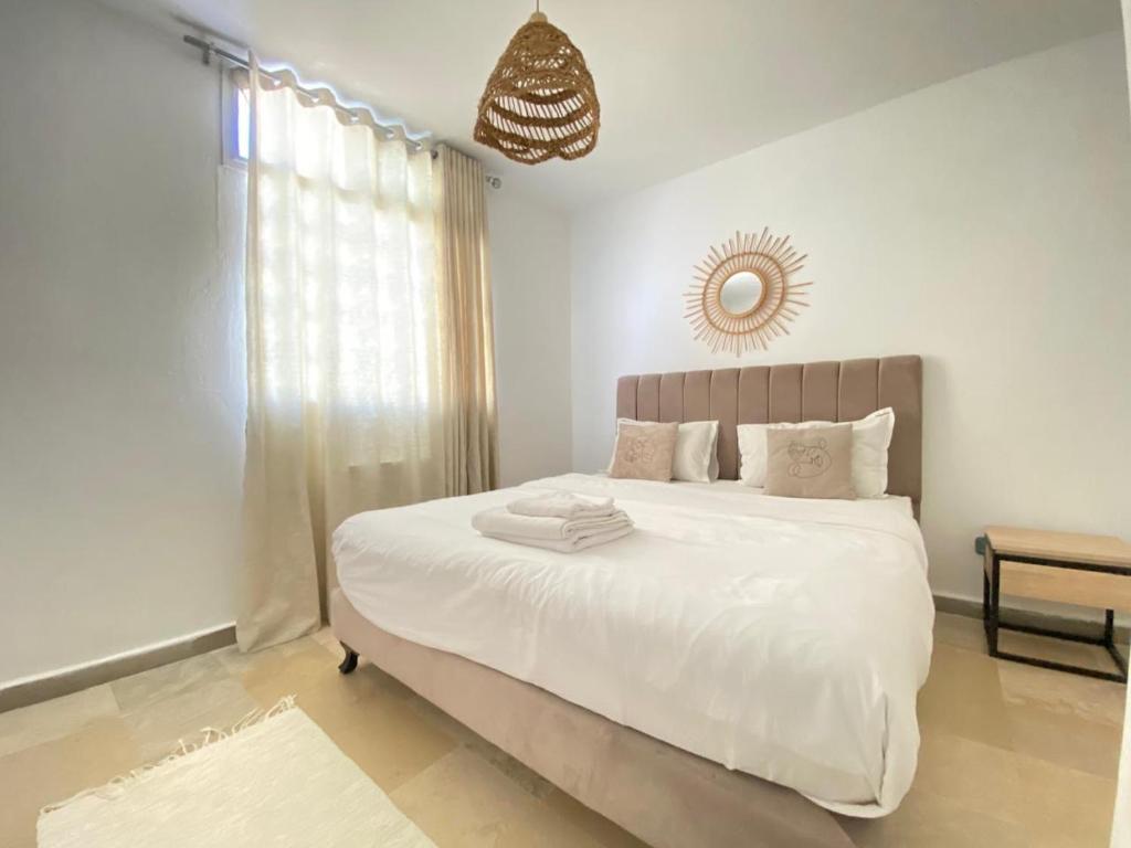 1 dormitorio blanco con 1 cama grande con sábanas blancas en Carthage vacation Home, en Túnez