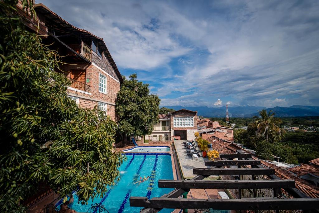 a swimming pool with benches next to a building at Hotel Plaza Menor in Santa Fe de Antioquia