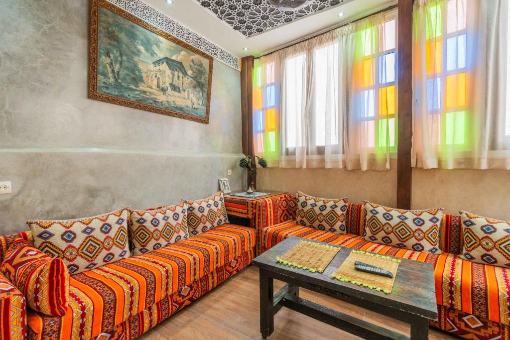 una sala de estar con un sofá y una mesa en Dar Namla, en Essaouira