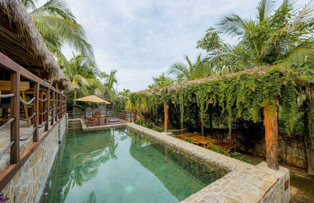 a swimming pool next to a building with a resort at Villa Aurema a Quiet Nature Retreat in Santa María Tonameca