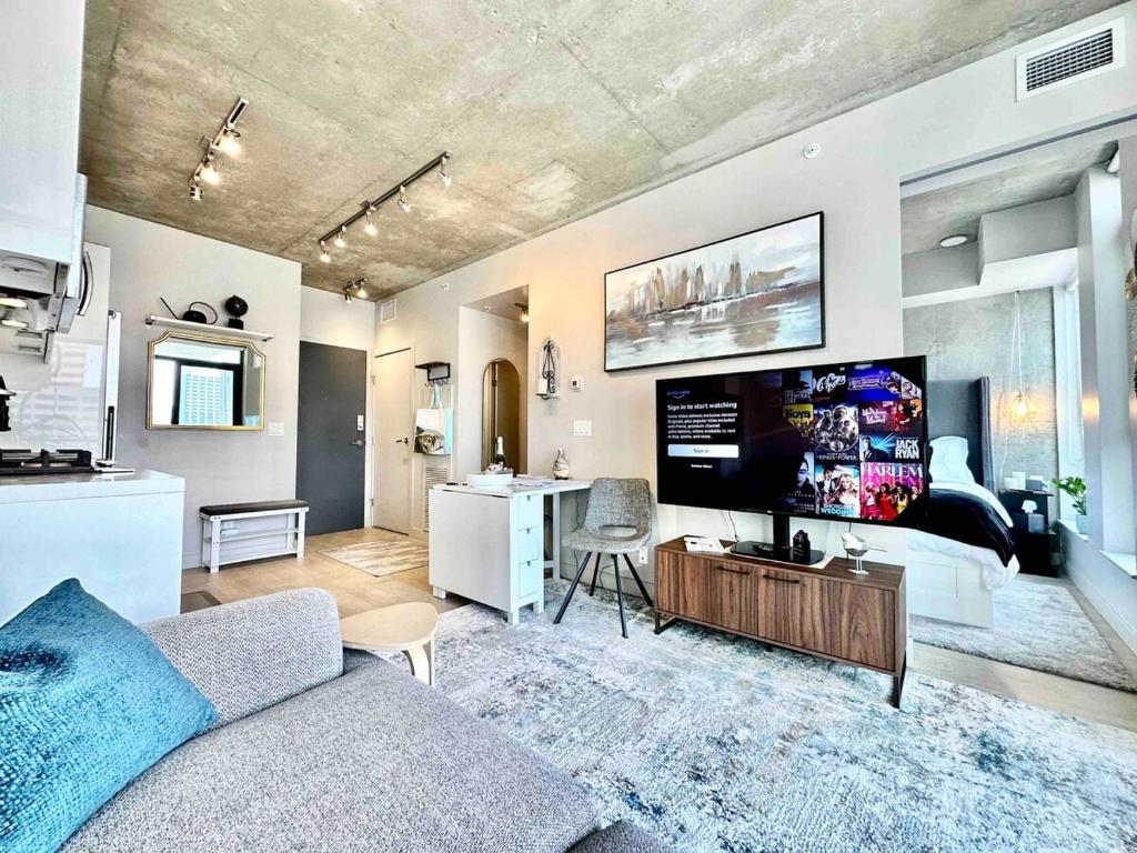 Una sala de estar con un sofá y un televisor de pantalla plana. en MicroNest - Modern Overlooking Downtown Parking, en Calgary