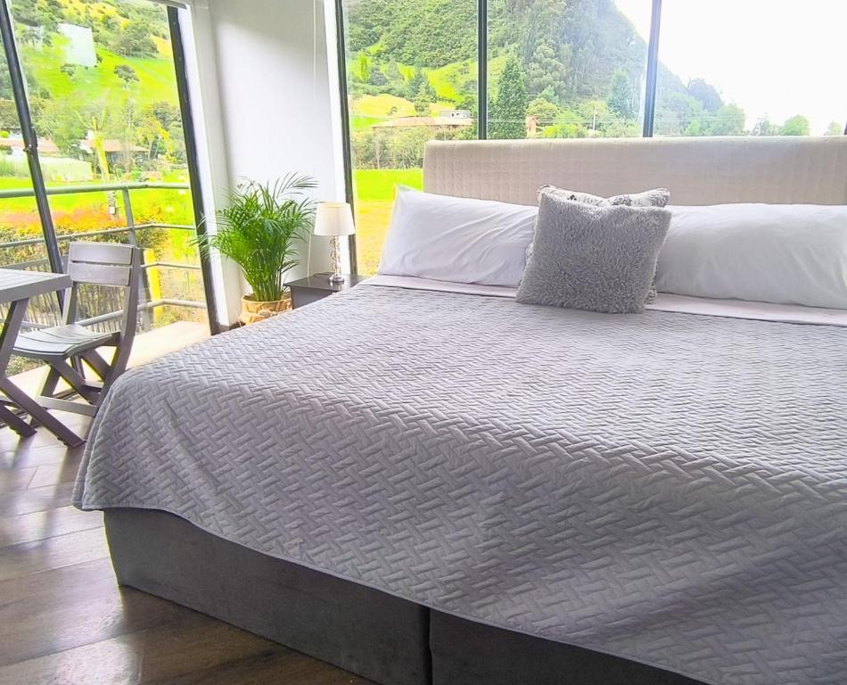 a bedroom with a large bed and a table and chairs at Comfort Campestre in Tabio