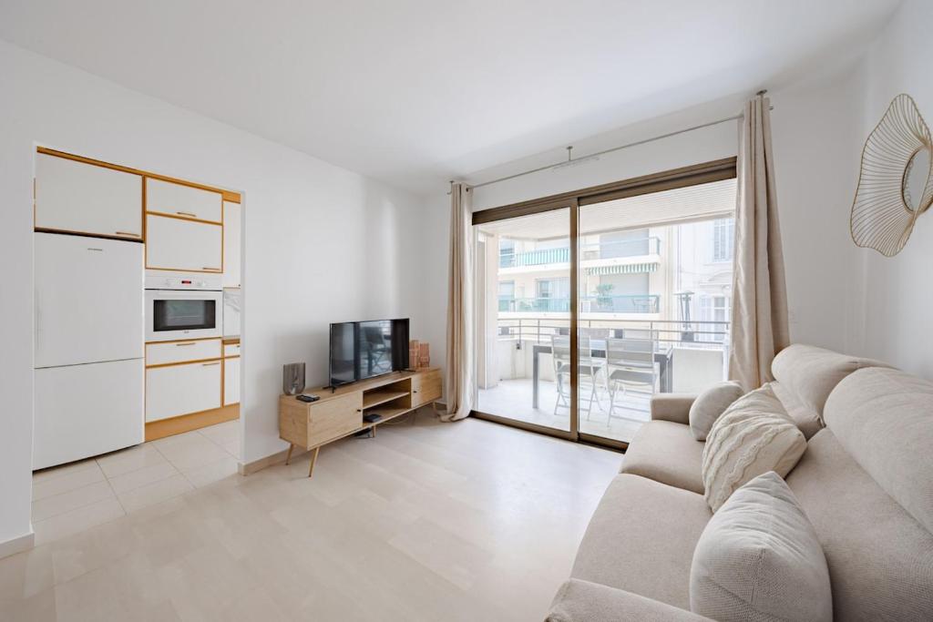 un salon blanc avec un canapé et une télévision dans l'établissement Cannes 2 bedrooms apartment - 141A, à Cannes