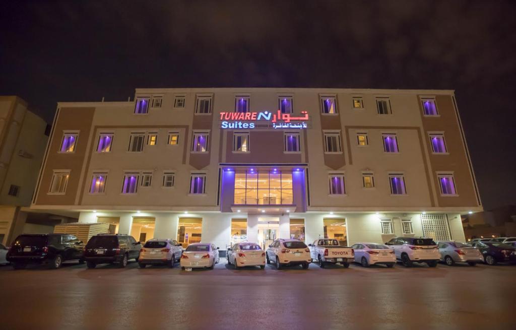 a large building with cars parked in front of it at توارن للشقق المخدومة الاقتصادية in Riyadh