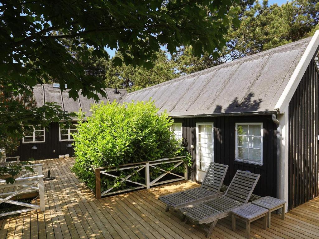 two chairs on a deck next to a house at 4 star holiday home in Liseleje in Liseleje