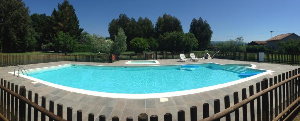 uma grande piscina com uma cerca em redor em Agriturismo Eucaliptus em Bolgheri