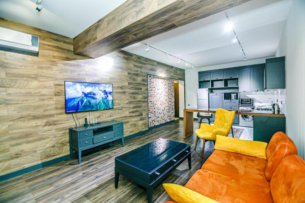 Una sala de estar con un sofá y un televisor. en Park Azure One Bedroom Luxury Apartment, en Baku
