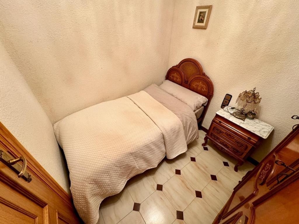 een kleine slaapkamer met een bed en een tafel bij Wagner Playa Apartment in Cullera