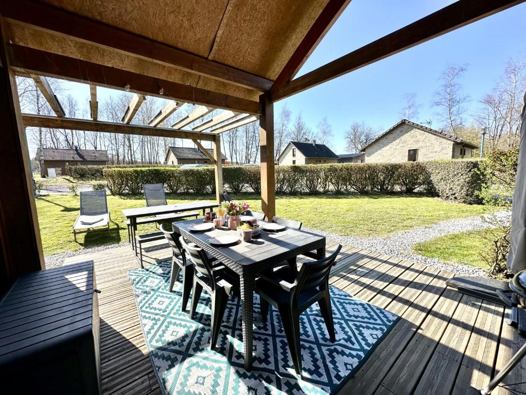 un patio avec une table et des chaises sur une terrasse dans l'établissement Pré Hugon 11, à Signy-le-Petit
