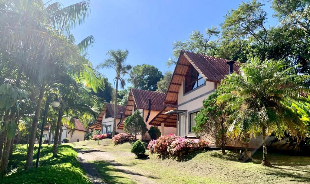 uma casa com palmeiras em frente em Pousada Highland em Santo Antônio do Pinhal