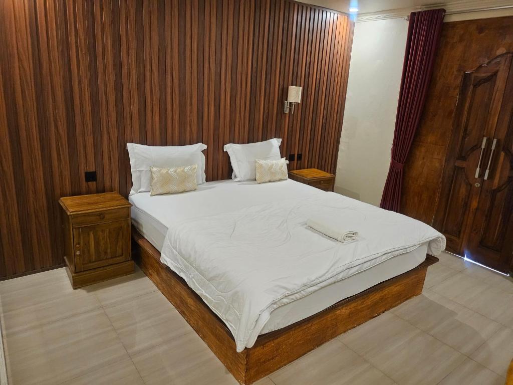 a bedroom with a large bed with white sheets and pillows at Rinjani Trekking Center in Senaru