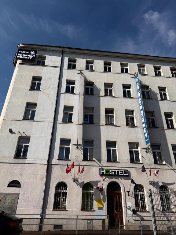 a large white building with a sign on it at Drunken Monkey Hostel in Prague