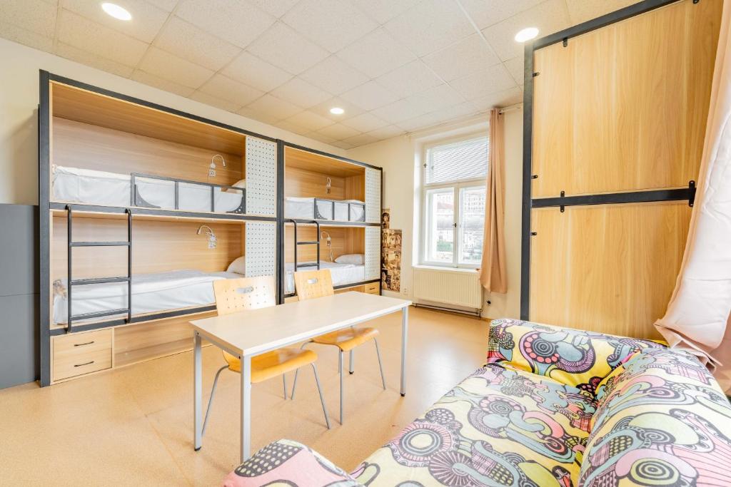 a living room with a couch and a table and bunk beds at Drunken Monkey Hostel in Prague