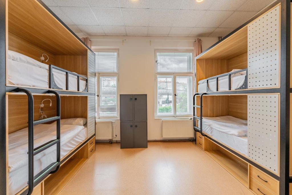 a dorm room with three bunk beds in it at Drunken Monkey Hostel in Prague