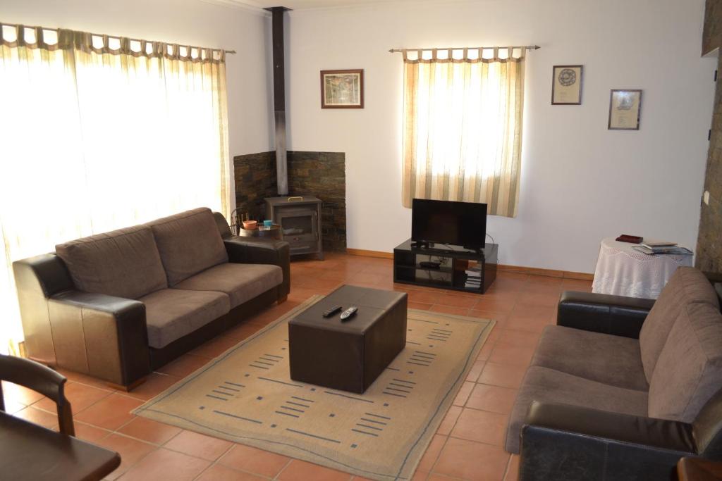 a living room with a couch and a tv at Quinta do Santo no Douro - Casa T3 in Alcarias