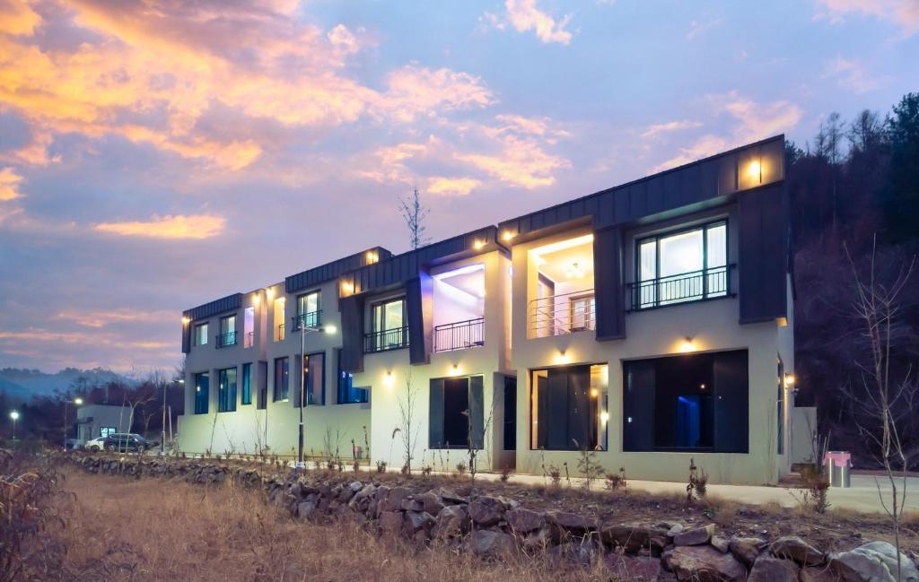 a house with a lot of windows on a hill at NJ Pool Villa in Hoengseong