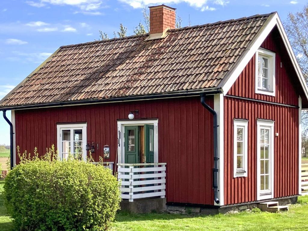 a red house with a brown roof at 2 person holiday home in ÖDESHÖG in Ödeshög