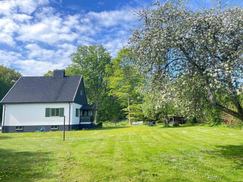 a white house with a black roof and a yard at 5 person holiday home in Stehag in Stehag