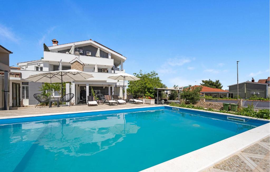 una grande piscina blu davanti a una casa di 1 Bedroom Nice Apartment In Vodice a Vodice