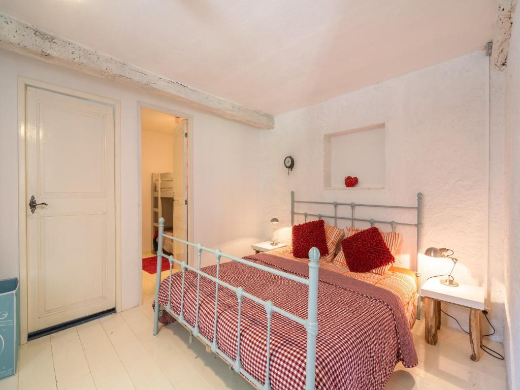 une chambre avec un lit avec des oreillers rouges dans l'établissement Villa in Artigat near Cathar Castles, cleaning included, à Artigat