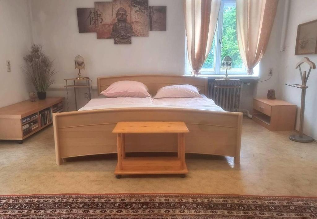 a bedroom with a large bed with a wooden table at Nr 9 Hübsche Suite mit Loggia in alte Villa mit Stadtblick und interessante Ausstattung Ohm Zimmer in Annaberg-Buchholz