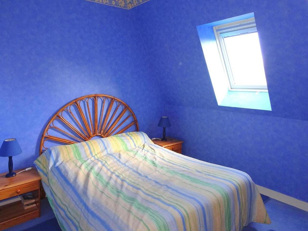 une chambre bleue avec un lit et une fenêtre dans l'établissement Apartment in St Quay near Seven Beaches, cleaning included, à Saint-Quay-Portrieux