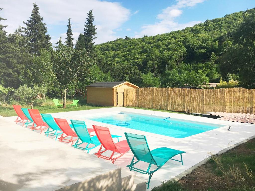 un groupe de chaises assises autour d'une piscine dans l'établissement Villa in Thueyts near Pont du Diable, cleaning included, à Thueyts
