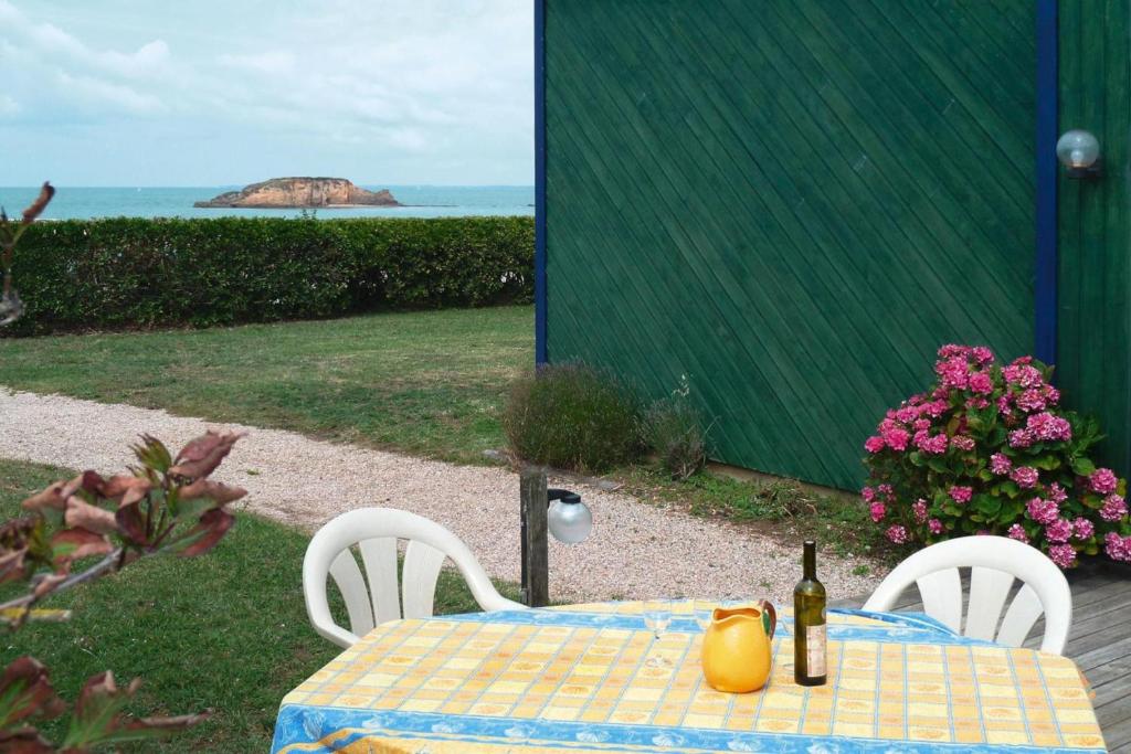 - une table avec 2 chaises et une bouteille de vin dans l'établissement Holiday Home in Penestin near La Mine d'Or Beach, cleaning included, à Pénestin