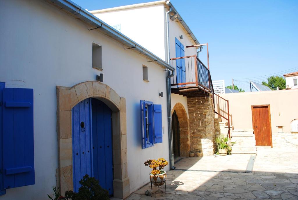 a white building with blue doors on it at To Archontiko tis Anastasias in Athienou