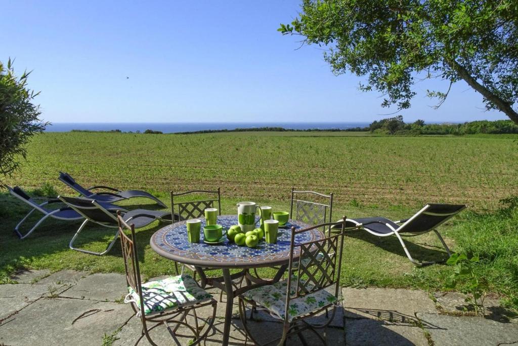 une table et des chaises avec une table et un champ dans l'établissement Stone House near Rosa Granite Coast, cleaning included, à Bas Kerhain