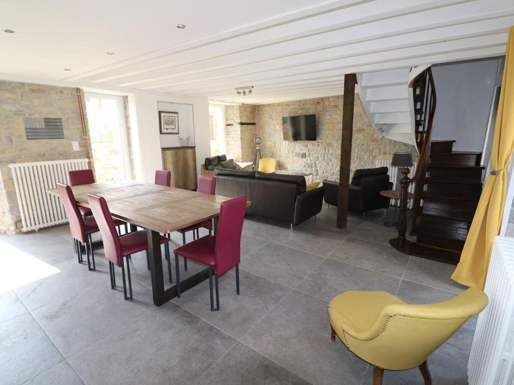 ein Esszimmer mit Tisch und Stühlen und ein Wohnzimmer in der Unterkunft Maison 8 personnes localisée au cœur de Sainte-Marie-du-Mont in Sainte-Marie-du-Mont