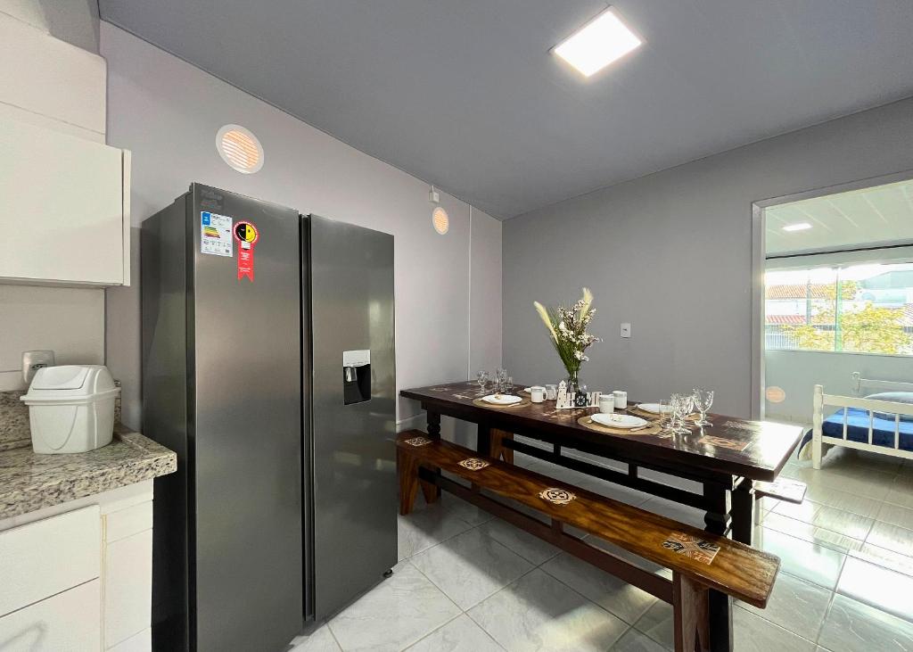 a kitchen with a table and a refrigerator at Vaz Beach Residence in Penha