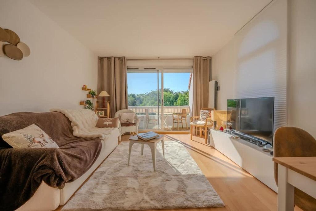 un salon avec un canapé et une télévision dans l'établissement Apartment of the Flying Bridges, à La Rochelle