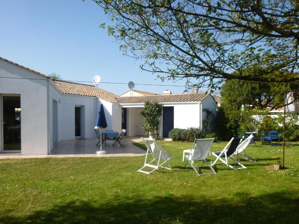 un groupe de chaises assises dans la cour d'une maison dans l'établissement Maison spacieuse avec jardin, proche forêt et plage, 3 chambres, équipements de loisirs, parking privé - FR-1-323-435, à Saint-Jean-de-Monts