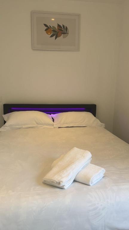 un lit blanc avec deux serviettes dessus dans l'établissement Royal appart city 2, à Calais