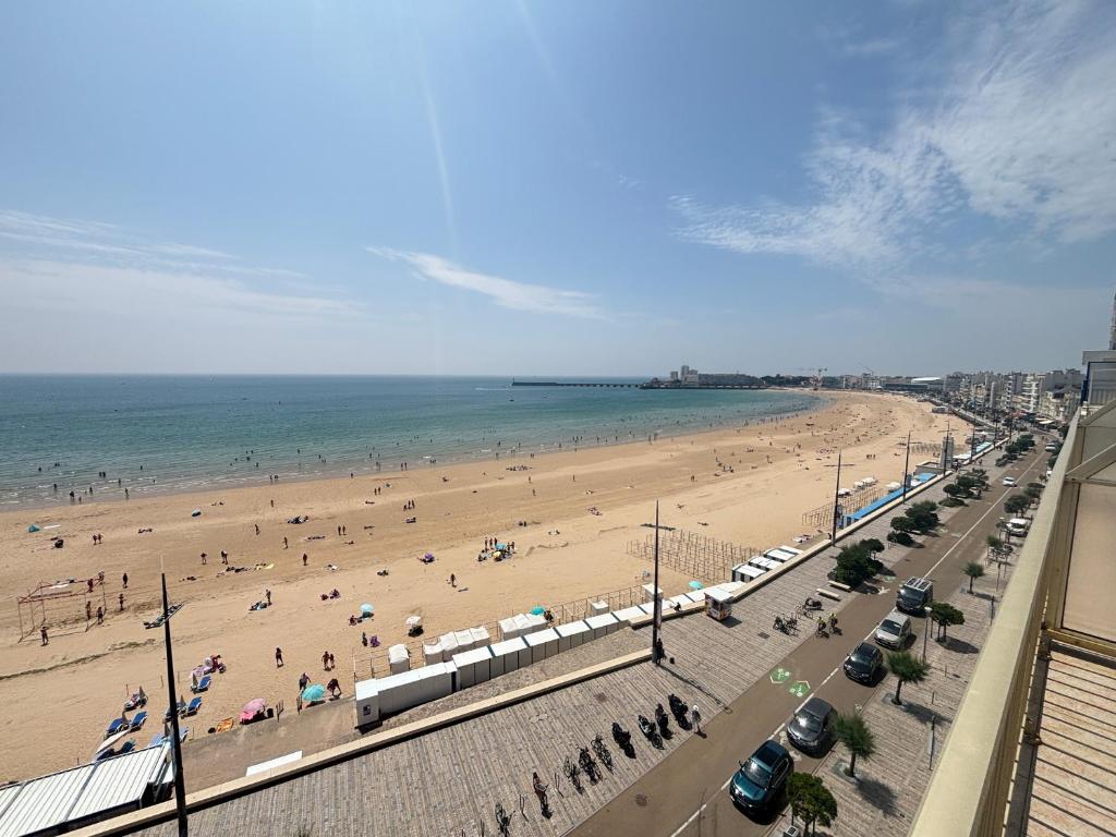 une plage avec beaucoup de monde et l'océan dans l'établissement Appartement avec terrasse face plage, 4 pers - FR-1-197-629, à Les Sables-dʼOlonne