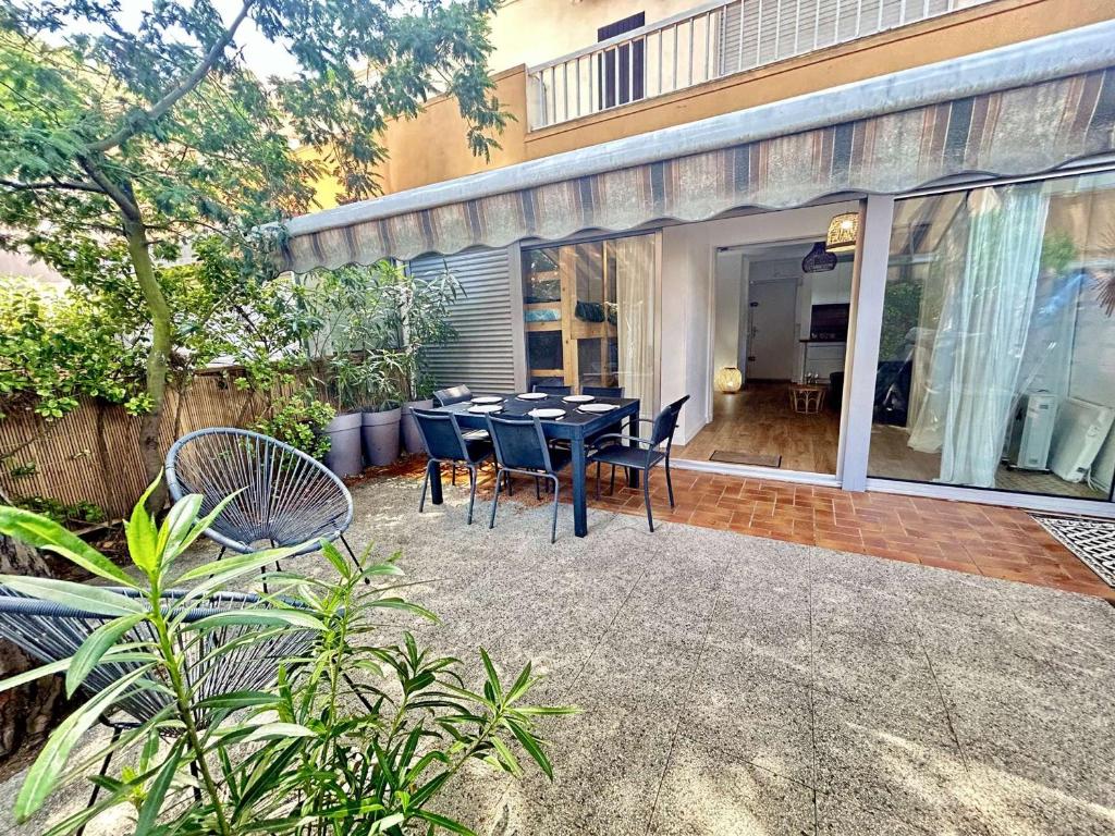 Une table à manger et des chaises sont disponibles sur la terrasse. dans l'établissement T2 et Cabine avec Piscine et Parking - Cap d'Agde - FR-1-249-441, au Cap d'Agde